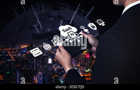 A businessman engages with a tablet displaying AI and SaaS icons against a stunning digital cityscape, showcasing the fusion of technology and modern Stock Photo