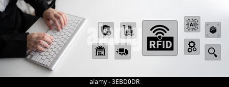 A modern workspace showcasing hands typing on a keyboard with RFID technology icons, illustrating the impact of innovation on logistics and inventory Stock Photo