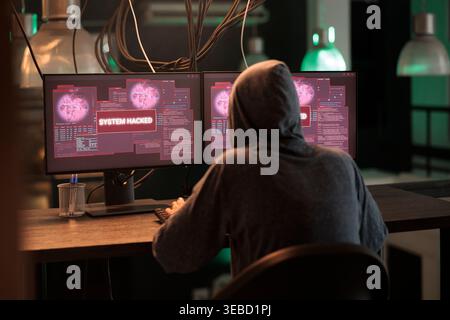 Internet thief creating security breach and hacking computer system, stealing important data or passwords. Young hacker planting trojan virus, breaking into database and programming software. Stock Photo