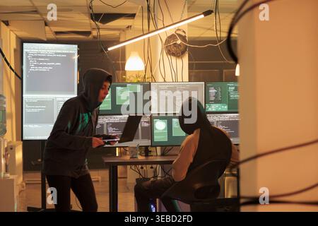 Hackers coding spyware, cracking database password, getting illegal access, data breach. Cybercrime, internet thieves hacking computer network system, developing malicious software Stock Photo