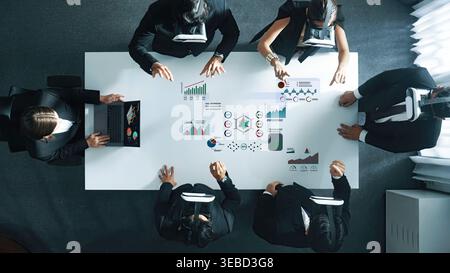 A professional business team wearing virtual reality headsets engages in a meeting, analyzing data visuals and collaborating on innovative solutions Stock Photo
