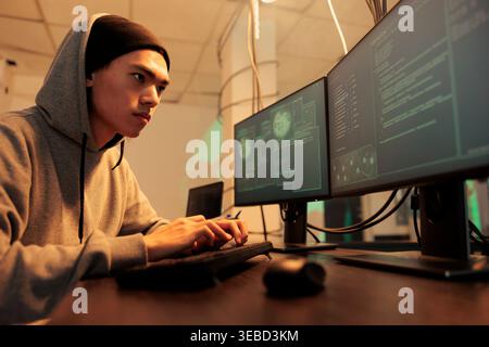 Cybercrime, computer fraud, man hacking system, coding malware, stealing database privacy information. Internet criminal cracking online server password, developing spyware at night time Stock Photo