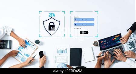 A team collaborates on cybersecurity solutions featuring two-factor authentication, showcasing technology tools like laptops and notebooks for data Stock Photo