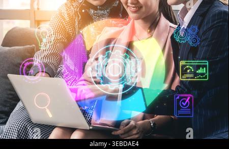 Collaboration of Business Professionals Analyzing Data with Laptop in Modern Office with Colorful Digital Icons and Graphics Representing Technology Stock Photo