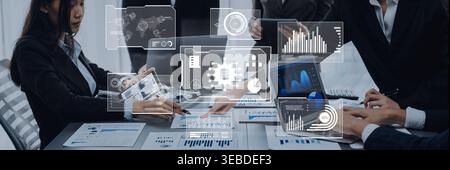 Business professionals engage in a collaborative meeting in a modern office, utilizing technology and data visualization tools for insightful analysis Stock Photo