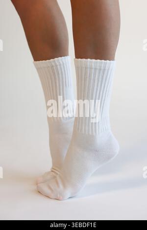 Female Legs Wearing White Ribbed Crew Socks Side View Minimal Studio Shot Stock Photo