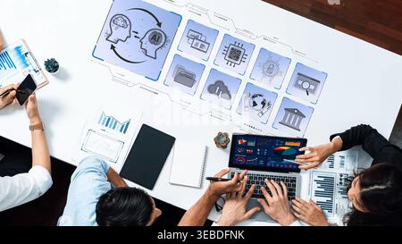 A collaborative workspace scene showcases professionals engaged in data analysis and technology discussion. Innovative tools and graphics enhance Stock Photo