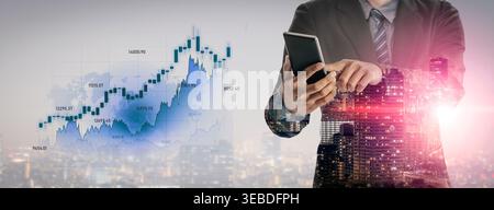 A businessman uses a smartphone while surrounded by financial graphs and a cityscape, representing business growth, technology, and modern finance Stock Photo