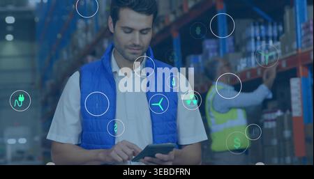 Scanning man in blue vest using handheld tablet in warehouse, worker wearing hi-vis vest, overlays Stock Photo