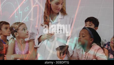 Holding teacher in lab coat showing rock specimen with hand lens at school table, projected grid Stock Photo