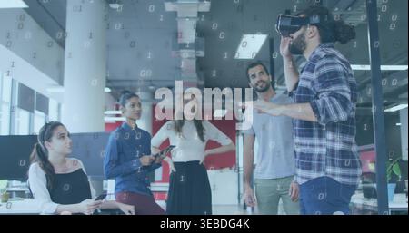 Demonstrating man wearing VR headset gesturing in modern office, with tablet, phone, binary overlay Stock Photo