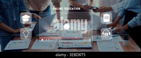 A diverse group of professionals collaborates on an online education project using laptops and digital tools, showcasing teamwork and innovation in a Stock Photo