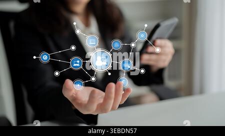 A business professional interacts with a smartphone while showcasing a digital network interface. This visual symbolizes communication, innovation Stock Photo