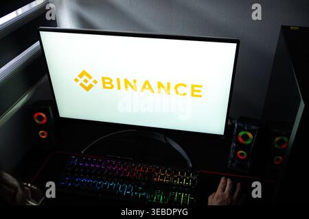 Close-up of a PC screen showing the yellow Binance brand icon and text in a home office setting Stock Photo
