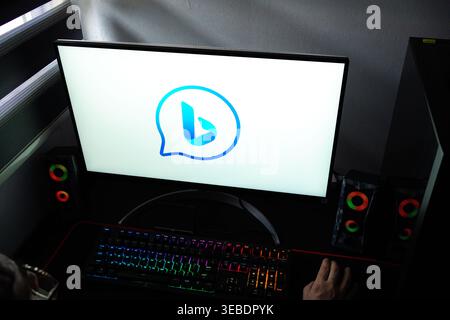 Close-up of a PC screen showing the blue Bing chat bubble icon in a home office setting Stock Photo