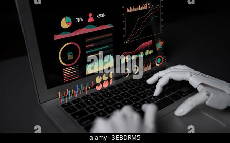 A futuristic robotic hand types on a laptop, showcasing vibrant data analytics and graphs in a dark setting, emphasizing innovation and technology Stock Photo