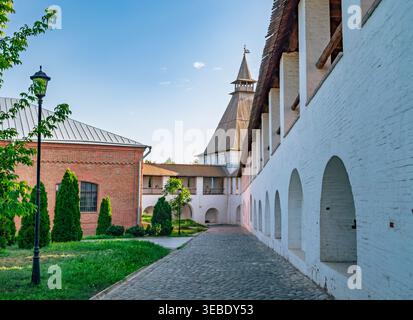 Astrakhan Kremlin inner grounds in Russia displaying historical white walls, cobblestone path, and a towering structure on a clear day Stock Photo