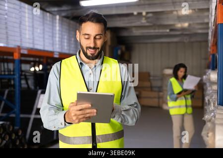 Male logistics specialist using digital tablet in warehouse Stock Photo