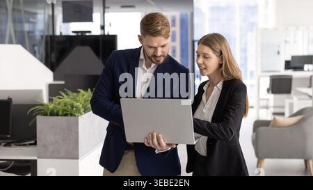 Colleagues engaged in productive teamwork using laptop Stock Photo