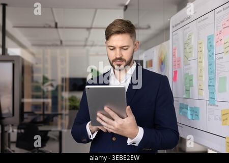 Businessman reviewing digital presentation or analyzing project plan on tablet Stock Photo