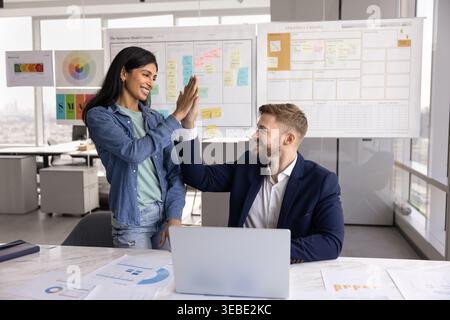 Two happy multinational colleagues exchanging high five Stock Photo