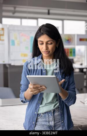 Pretty Indian professional woman working on tablet Stock Photo