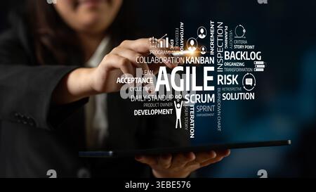 A business professional interacts with a tablet showcasing agile concepts. This image emphasizes modern strategies for project management Stock Photo