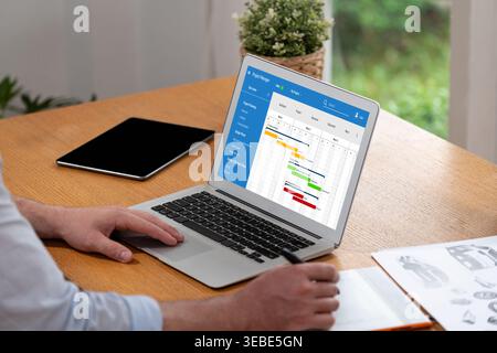 Project planning software for brisk business project management on the computer screen showing timeline chart of the team project Stock Photo