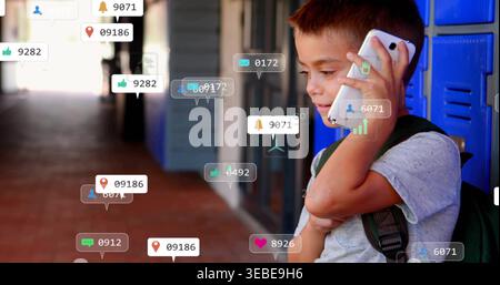 Holding white phone boy with green backpack talking near blue lockers with icons, copy space Stock Photo