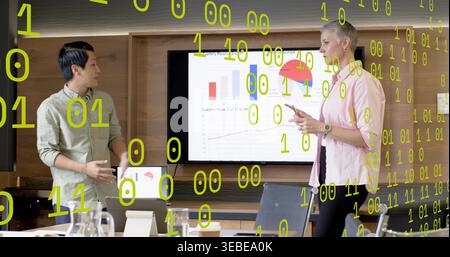 Presenting two presenters in suits pointing at screen in meeting room, with laptop, green overlay Stock Photo