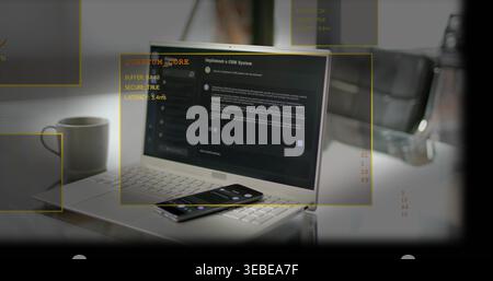 Displaying silver laptop running dark CRM app on white table, smartphone and yellow AR overlays Stock Photo