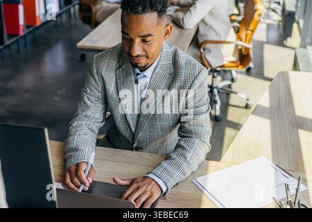 Developer Working Diligently. Software Engineer Focused On Task With Notes And Two Monitors Visible Stock Photo