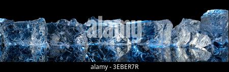 Broken ice with blue backlight on a black reflective background. Copy space. Stock Photo