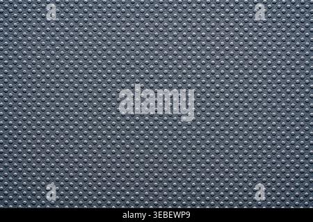 Grey perforated texture background with dotted pattern. Macro shot of a dark grey synthetic surface with a regular raised dot pattern. Modern industri Stock Photo