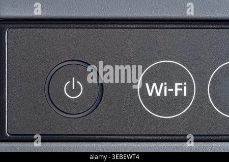 Close up of power and Wi-Fi buttons on electronic device panel. Macro shot of control panel. Concept of wireless technology modern office equipment an Stock Photo