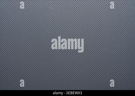 Grey perforated texture background with dotted pattern. Macro shot of a dark grey synthetic surface with a regular raised dot pattern. Modern industri Stock Photo