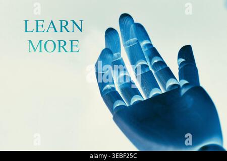 Close-up of a robotic hand pointing toward the text "Learn More", representing user engagement, information access, and digital interaction. Futuristi Stock Photo