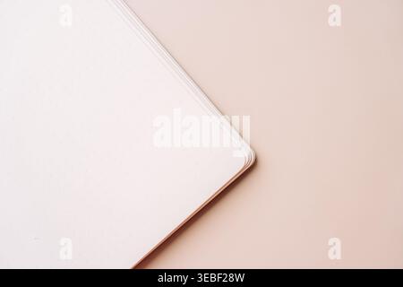 Notebook corner on beige background with soft light Stock Photo