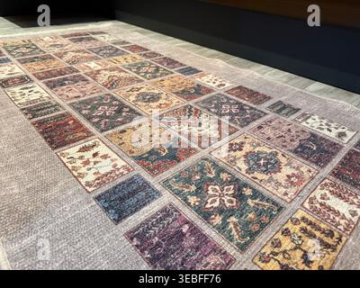 Ornate patterned rug with colorful geometric design on wooden floor background. Mobile photo Stock Photo