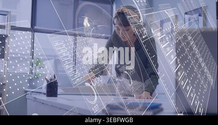 Analyzing Asian woman wearing glasses and dark sweater examining tablet at office, with AR overlays Stock Photo