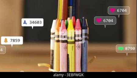 Displaying bundle wax crayons standing on wooden table, with rubber band, pencils and notifications Stock Photo