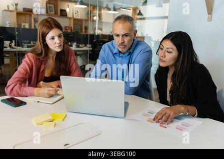 Business colleagues collaborating on project, discussing startup strategy Stock Photo