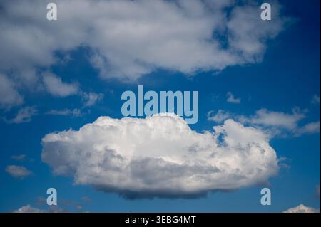 Bright white cloud floating in deep blue sky Stock Photo