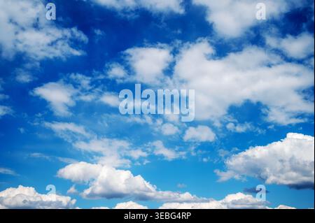 Blue sky filled with scattered white clouds background Stock Photo