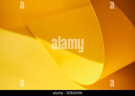 Yellow paper surface creating abstract curves, light and shadows Stock Photo