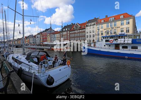 Nyhavn canal in Copenhagen, viewed east from near Kongens Nytorv with colourful harbour houses, boats and waterfront restaurants. Stock Photo