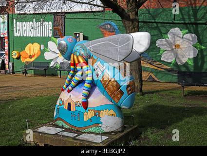 Levenshulme Village Green Bee in the City sculpture with mural backdrop, Greater Manchester community public art. Stock Photo