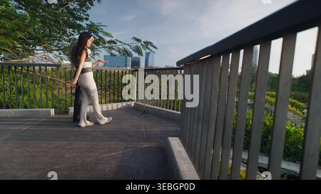 Young woman recording a video for social media on a rooftop terrace, showcasing the cityscape Stock Photo