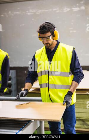 Factory worker operating machinery in a lumberyard Stock Photo