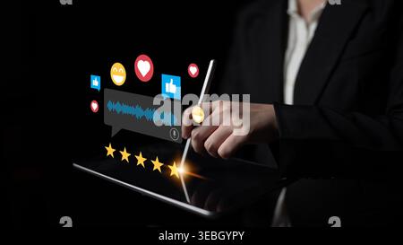 A business professional interacts with a tablet, showcasing digital communication through emoticons and ratings, symbolizing user feedback and Stock Photo